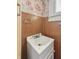 This bathroom features wood paneling, patterned wallpaper, and a bright, clean sink at 4715 E New York St, Indianapolis, IN 46201