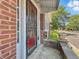 A front porch view with brick accents, a decorative security door, and greenery enhancing the home's entrance at 4715 E New York St, Indianapolis, IN 46201