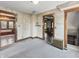 View of a carpeted living room with vintage fixtures and multiple entryways at 4715 E New York St, Indianapolis, IN 46201