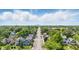 An aerial view of a residential street showcasing tree coverage and houses, with a city skyline in the distance at 4715 E New York St, Indianapolis, IN 46201