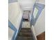 Stairwell leading down, featuring carpeted steps and a blue door at 4715 E New York St, Indianapolis, IN 46201