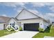 Side view of a modern single-story home with black garage door and a well-maintained lawn at 4726 Amber Wood Ln, Indianapolis, IN 46235