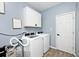 Convenient laundry room with a washer, dryer, and white overhead cabinets at 4726 Amber Wood Ln, Indianapolis, IN 46235