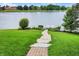 Scenic backyard with stone pathway leading to a serene lake with a dock at 4810 Crystal River Ct, Indianapolis, IN 46240