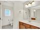 Well-lit bathroom featuring a wooden vanity, a large mirror, and a separate toilet area at 4810 Crystal River Ct, Indianapolis, IN 46240