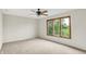 Bright bedroom with carpet, a ceiling fan, and a large window offering a serene view of lush greenery at 4810 Crystal River Ct, Indianapolis, IN 46240
