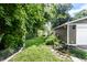 Well-maintained backyard with green grass, koi pond, lush greenery, and outbuildings at 5119 Norwaldo Ave, Indianapolis, IN 46205