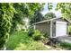 Well-maintained backyard with a koi pond, green grass, lush greenery, and outbuildings at 5119 Norwaldo Ave, Indianapolis, IN 46205