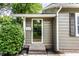Home exterior featuring the front door, siding, and decorative bushes at 5119 Norwaldo Ave, Indianapolis, IN 46205