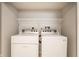 Modern laundry area featuring a white washer and dryer set with wire shelving for convenient storage at 5119 Norwaldo Ave, Indianapolis, IN 46205