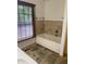 Bathroom featuring a soaking tub with tile surround and a window with natural light at 5530 Shawnee Trail South Dr, Indianapolis, IN 46220