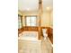 Bathroom featuring a soaking tub with jets, a toilet, and wooden paneling at 5530 Shawnee Trail South Dr, Indianapolis, IN 46220