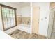 Bathroom featuring a bathtub with tile surround and a window with wood blinds at 5530 Shawnee Trail South Dr, Indianapolis, IN 46220