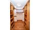 Walk-in closet with hardwood floors and built-in shelving and clothing rods at 5530 Shawnee Trail South Dr, Indianapolis, IN 46220