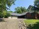 Home exterior showcasing a driveway, three car garage, brick accent, and partial landscaping at 5530 Shawnee Trail South Dr, Indianapolis, IN 46220