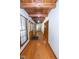 Inviting hallway with hardwood floors, wood-paneled ceiling, and natural light from large windows at 5530 Shawnee Trail South Dr, Indianapolis, IN 46220