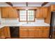 Kitchen area with wooden cabinets, white countertops, a double sink, and modern appliances at 5530 Shawnee Trail South Dr, Indianapolis, IN 46220