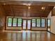 Bright living room with hardwood floors, beamed ceilings, and a wall of windows leading to the outdoors at 5530 Shawnee Trail South Dr, Indianapolis, IN 46220