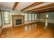 Open living room with hardwood floors, stone fireplace, and large windows at 5530 Shawnee Trail South Dr, Indianapolis, IN 46220
