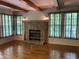 Living room with hardwood floors, stone fireplace, and wooden beams on ceiling at 5530 Shawnee Trail South Dr, Indianapolis, IN 46220