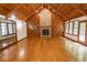 Spacious living room featuring a stone fireplace, hardwood floors, and wood-paneled vaulted ceilings at 5530 Shawnee Trail South Dr, Indianapolis, IN 46220