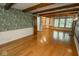 Spacious living room with wood floors, beamed ceilings, custom wallpaper and built-in shelving at 5530 Shawnee Trail South Dr, Indianapolis, IN 46220