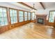 Sun-drenched living room with hardwood floors, wood beams, and fireplace at 5530 Shawnee Trail South Dr, Indianapolis, IN 46220