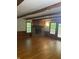 Bright living area with hardwood floors, a stone fireplace, wooden beams, and natural light at 5530 Shawnee Trail South Dr, Indianapolis, IN 46220