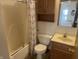 Bathroom with tub, patterned shower curtain, toilet, vanity, and wood cabinet at 5632 Spring Mist Cir, Indianapolis, IN 46237