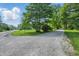 Scenic view of the property's driveway leading to a charming home surrounded by lush greenery and mature trees at 5824 Wesley Rdg, Martinsville, IN 46151