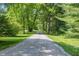 Scenic view of a long, gravel driveway lined with mature trees, leading to a private residence at 5824 Wesley Rdg, Martinsville, IN 46151