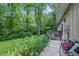 Well-maintained home exterior with lush greenery, shrubs, and a partial view of the wooden deck at 5824 Wesley Rdg, Martinsville, IN 46151