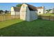 View of backyard featuring two storage sheds and well-maintained lawn enclosed by wooden picket fence at 5850 Pennekamp Dr, Plainfield, IN 46168