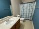 This is a full bathroom with a shower with curtain, toilet, vanity with sink and modern fixtures at 5850 Pennekamp Dr, Plainfield, IN 46168