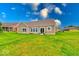 A spacious backyard features manicured grass and a patio with seating at 59 Manchester Dr, Trafalgar, IN 46181