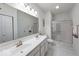 Bathroom featuring glass shower, dual sinks, and white marbled tile at 59 Manchester Dr, Trafalgar, IN 46181