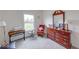 Bright bedroom features a large window, vintage dresser, lamp, and plush carpeting at 59 Manchester Dr, Trafalgar, IN 46181