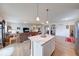 Open floor plan showing kitchen island, living room, and dining area with hardwood flooring at 59 Manchester Dr, Trafalgar, IN 46181