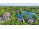 Community aerial showcasing homes around a lake and beautiful trees at 5940 Chapmans Trl, Carmel, IN 46033