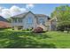 Backyard view of a home with a well-maintained lawn, a wooden deck, and mature landscaping at 5940 Chapmans Trl, Carmel, IN 46033