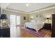 Spacious primary bedroom with a large bed, wood floors, and sliding glass door leading to outdoor area at 5940 Chapmans Trl, Carmel, IN 46033