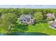 Exterior view of back of house with a deck overlooking beautifully manicured lawn near a pond at 5940 Chapmans Trl, Carmel, IN 46033