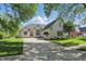 Charming brick home featuring lush landscaping, mature trees, and ample driveway space at 5940 Chapmans Trl, Carmel, IN 46033