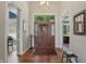 Inviting foyer featuring hardwood floors, a stylish light fixture, and views into adjoining rooms at 5940 Chapmans Trl, Carmel, IN 46033