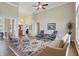 Bright living room featuring high ceilings, a ceiling fan, and views of the front entry at 5940 Chapmans Trl, Carmel, IN 46033