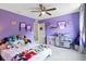 Charming bedroom with purple walls and a ceiling fan, plus a toy kitchen at 6107 Flagler Ln, Brownsburg, IN 46112