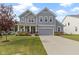 Charming two-story home with gray siding, a well-manicured lawn, and an attached two-car garage at 6107 Flagler Ln, Brownsburg, IN 46112
