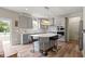 Bright kitchen boasts gray cabinets, quartz countertops, island with seating, and stainless steel appliances at 6107 Flagler Ln, Brownsburg, IN 46112