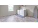 Bright laundry room with white washer and dryer, plus shelving above, and a window for natural light at 6107 Flagler Ln, Brownsburg, IN 46112