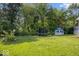Spacious backyard with trampoline, playhouse, manicured lawn, and wooded border at 6133 Buttonwood Dr, Noblesville, IN 46062